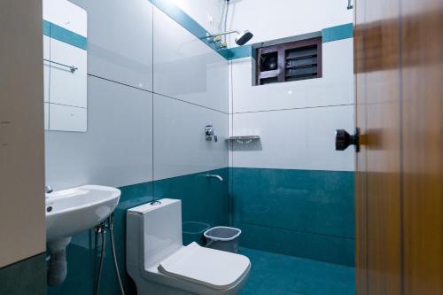 a bathroom with a toilet and a sink at Hotel Aeronest Residency in Calicut