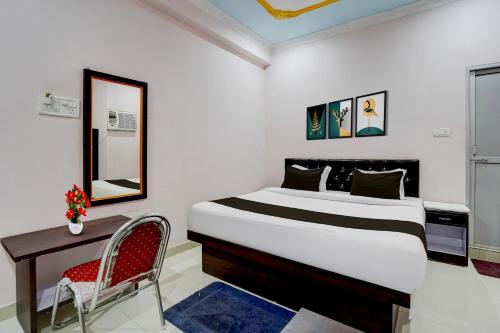a bedroom with a bed and a desk and a mirror at Super Collection O Patna Airport Formerly Hotel Shahi Mahal in Dānāpur