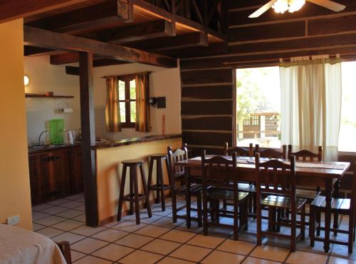 een keuken en eetkamer met een tafel en stoelen bij Cabañas Los Maderos in Villa General Belgrano