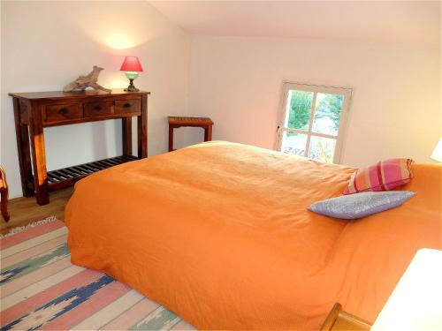 - un lit orange dans une chambre avec fenêtre dans l'établissement La Maison de l'Isle, à LʼIsle-sur-la-Sorgue