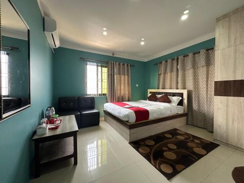 a bedroom with green walls and a bed and a table at Chareli Resort in Nagarkot
