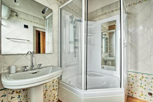 a bathroom with a sink and a shower at Poggiluglio by PosarelliVillas in San Gimignano