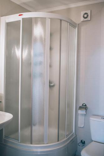 a shower in a bathroom with a sink and a toilet at Fermerska Hata in Dubno