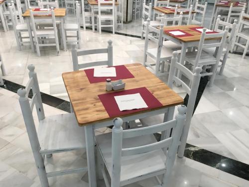 a wooden table and chairs in a restaurant at Hotel San Pablo Sevilla in Seville