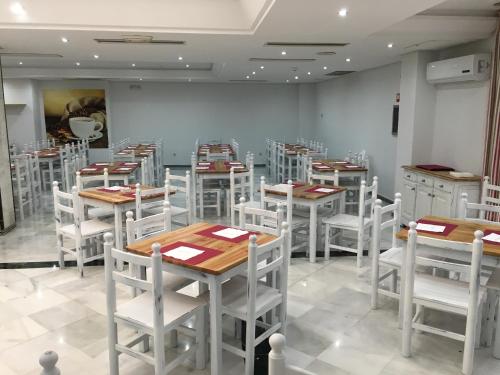 a dining room with tables and white chairs at Hotel San Pablo Sevilla in Seville