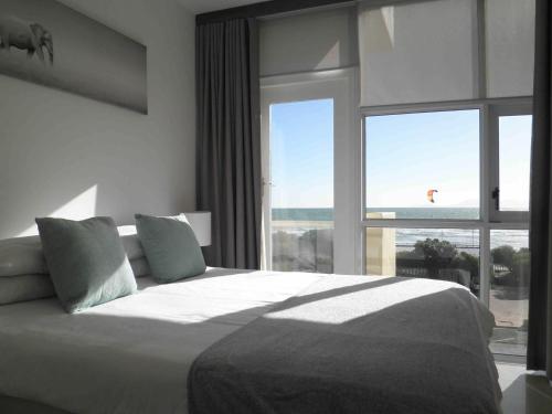 a bedroom with a large bed with a large window at 308 St Tropez in Strand