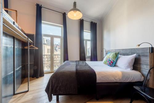 a bedroom with a bed and a large window at Smartflats - Sablon Brussels in Brussels