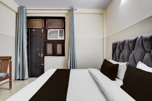 a bedroom with a large bed and a window at Super Hotel O Dwarka Mor Metro Station in New Delhi