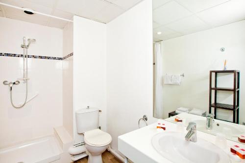 une salle de bain blanche avec toilettes et lavabo dans l'établissement Séjours & Affaires Tours Léonard De Vinci, à Tours