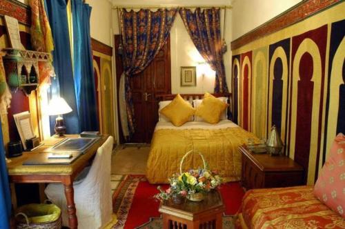 1 dormitorio con cama, escritorio y cama sidx sidx sidx sidx en Riad Dalia, en Marrakech