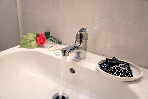 un lavandino in bagno con acqua che scorre da un rubinetto di Camere Delfini a Palmanova