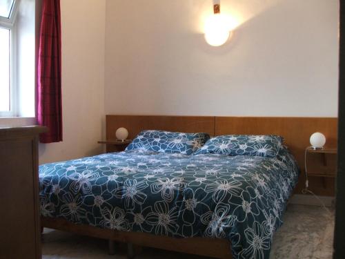 サン・フェリーチェ・チルチェーオにあるEdvige' S House in Residenceのベッドルーム1室(青と白の掛け布団付きのベッド1台付)