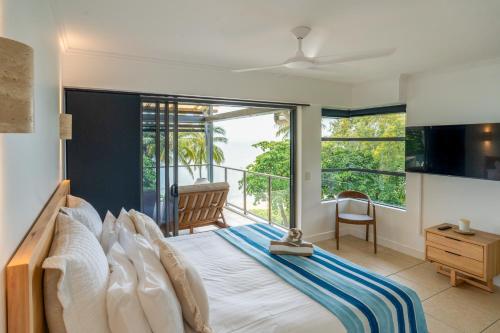 a bedroom with a large bed and a balcony at Sea Point on Trinity Beach in Trinity Beach