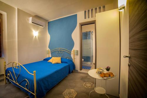- une petite chambre avec un lit bleu et une table dans l'établissement Marghaerita B&B, à Cetraro