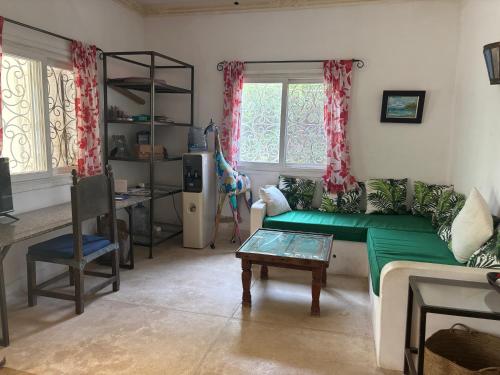 a living room with a green couch and a table at Downtown Malindi Apartment in Malindi