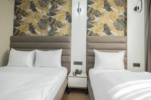two beds sitting next to each other in a bedroom at Dedem Hotel Dinlenme Tesisleri-Sultanhanı in Sultanhanı