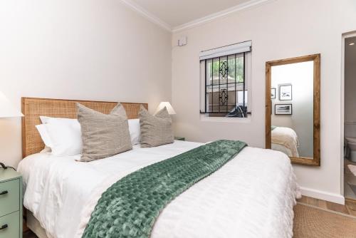 a bedroom with a large bed and a mirror at 2 on Hope in Simonʼs Town