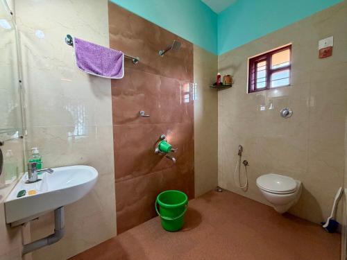 a bathroom with a sink and a toilet and a shower at Laksh Nivas Fields Stay in Udupi