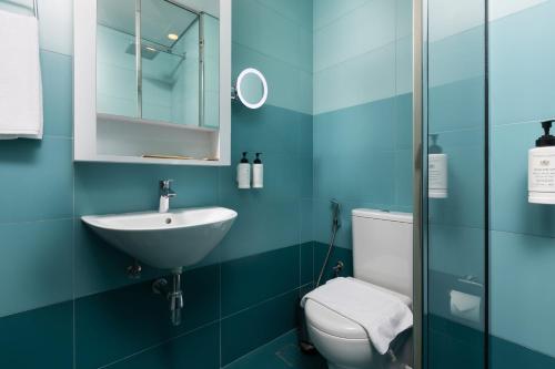 a blue bathroom with a sink and a toilet at Nest Hotel, Aljada in Sharjah