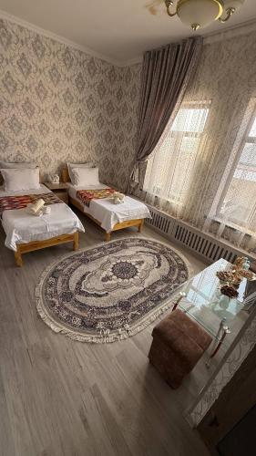 a living room with two beds and a rug at Home Villa YaaxYa in Bukhara