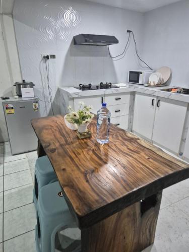 a kitchen with a wooden table with a bottle of water on it at Navo Apartment Homes in Nadi