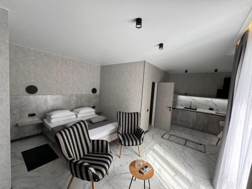 a hotel room with a bed and two chairs at Urban Nest in Truskavets