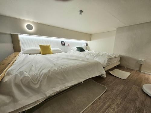 a bedroom with a large white bed with yellow pillows at 샤인 스테이 in Kung-mal