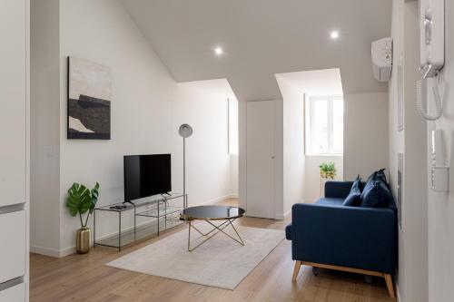 a living room with a blue couch and a tv at Lisbon Nest 2BR in Lisbon