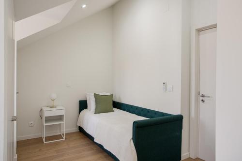 a bedroom with a bed with a green couch at Lisbon Nest 2BR in Lisbon
