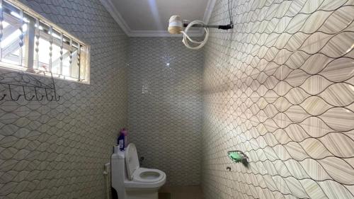 a bathroom with a white toilet and a window at Maasai Hostel Tanzania in Arusha
