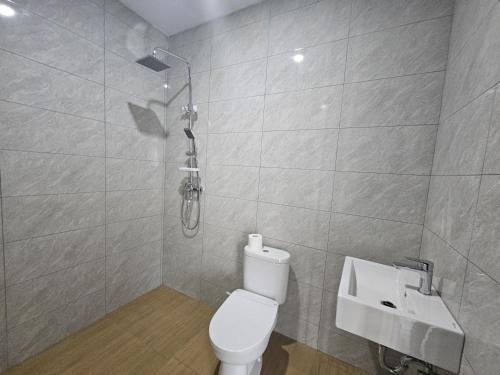 a bathroom with a shower and a toilet and a sink at Arkana Homestay in Tabanan
