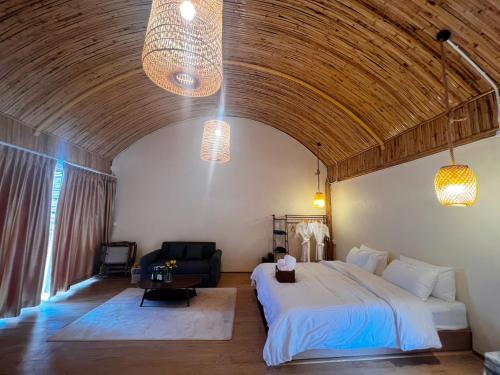a bedroom with a bed and a couch and two lights at Doi Chang Triple A Coffee in Ban Huai Khai