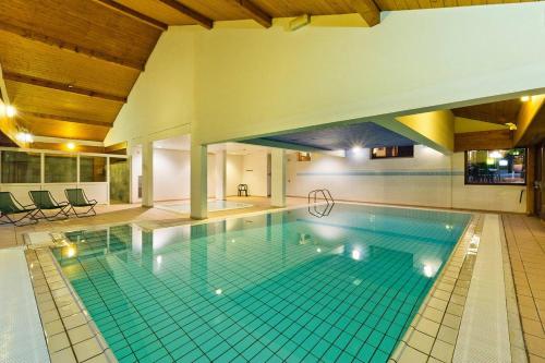 une grande piscine dans un immeuble dans l'établissement Hôtel Le Bellevue, à Thollon-les-Mémises