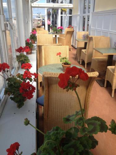 a restaurant with tables and chairs with red flowers at The Royal Hotel Cromarty in Cromarty