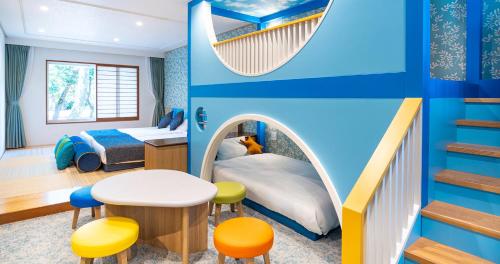 a childrens bedroom with a bed and a table and stools at Seagaia Forest Cottages in Miyazaki