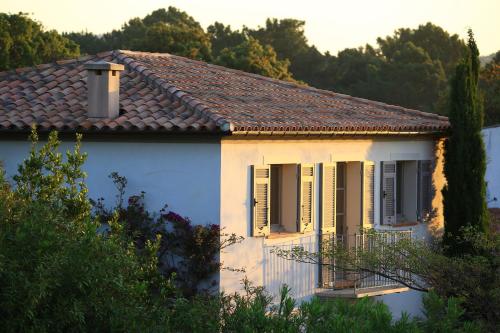 a white house with a brown roof at Le Pinarello in Sainte-Lucie de Porto-Vecchio