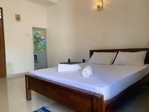 a bedroom with a large bed with white sheets at New Papa Palace in Wattegama
