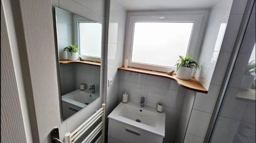 a bathroom with two sinks and two mirrors at Chez Auguste - charmant studio 3 étoiles in Chaponost