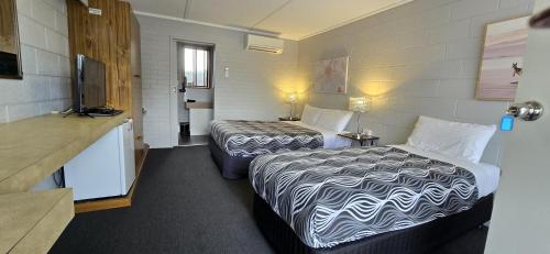 a hotel room with two beds and a television at Mariner Motel in Portland