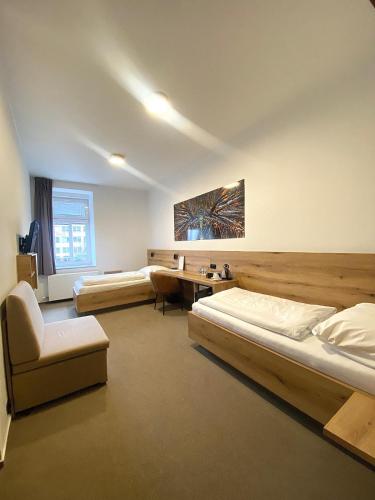a bedroom with two beds and a desk and a chair at Hotel U Labutě in Žďár nad Sázavou