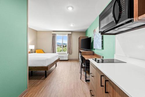a hotel room with a bed and a kitchen at ECHO Suites Extended Stay by Wyndham Reno in Reno