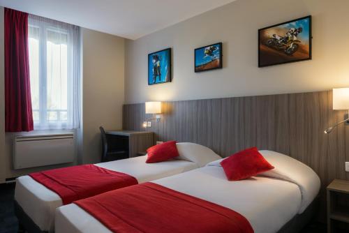 a hotel room with two beds with red pillows at Reims Hotel in Paris