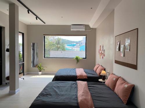 a bedroom with a large bed and a window at Phieu Brew Homestay in Hà Tiên