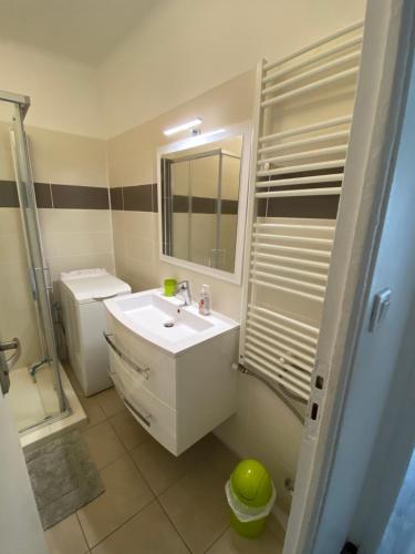 a white bathroom with a sink and a shower at Bel Appartement Residence Mirabeau in Aix-en-Provence