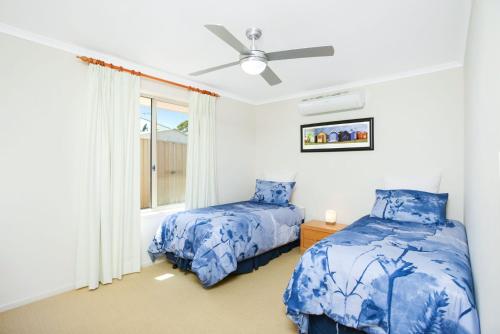 a bedroom with two beds and a window at 2 Marto Court in Normanville