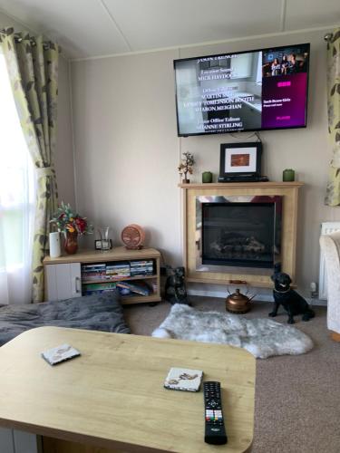 a living room with a tv above a fireplace at The Brend - Seaview holiday home in Newbiggin-by-the-Sea