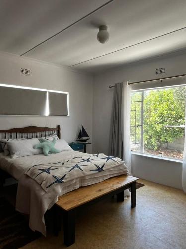 a bedroom with a large bed and a window at Casa Bella in Dwarskersbos