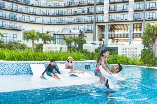 a group of people sitting in the water in a swimming pool at Hilton Okinawa Miyako Island Resort in Miyako-jima