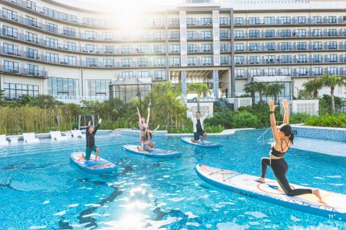 a group of people riding surfboards in the water at a hotel at Hilton Okinawa Miyako Island Resort in Miyako-jima