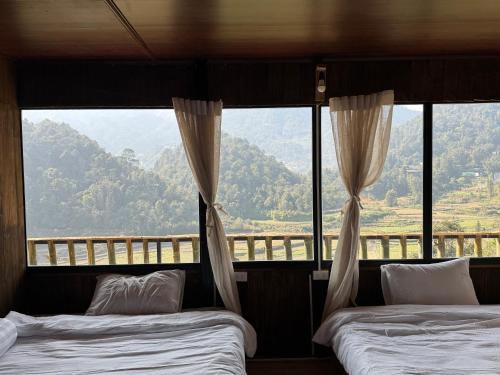 two beds in a room with a view of a mountain at Bản Sù - Homestay in Sapa